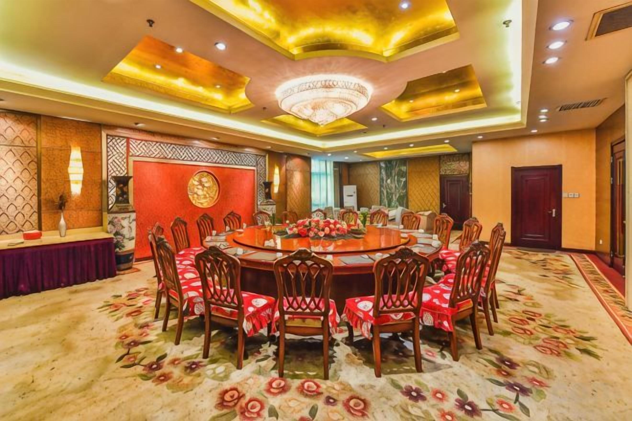 A conference room with a round table, chairs, and a carpeted floor.