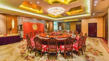 A conference room with a round table, chairs, and a carpeted floor.