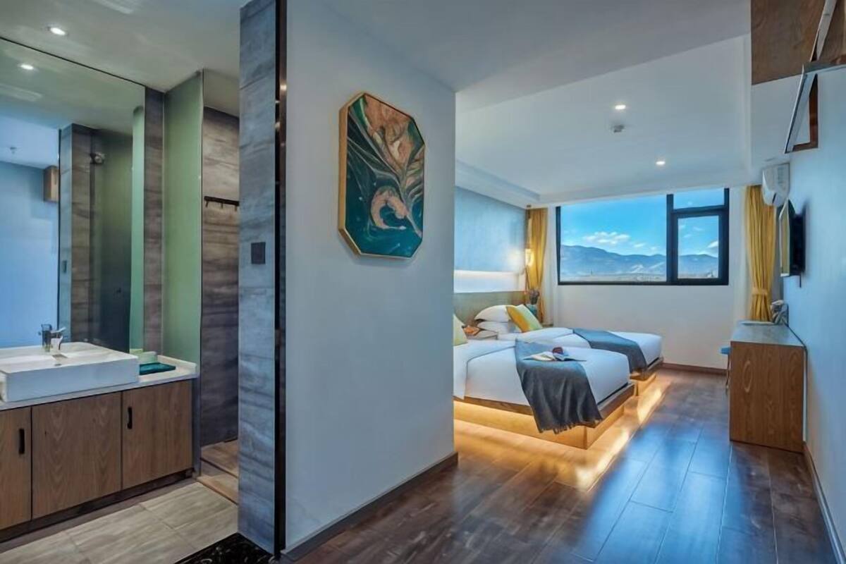 Un dormitorio moderno con cama, mesita de noche y vistas al exterior.
