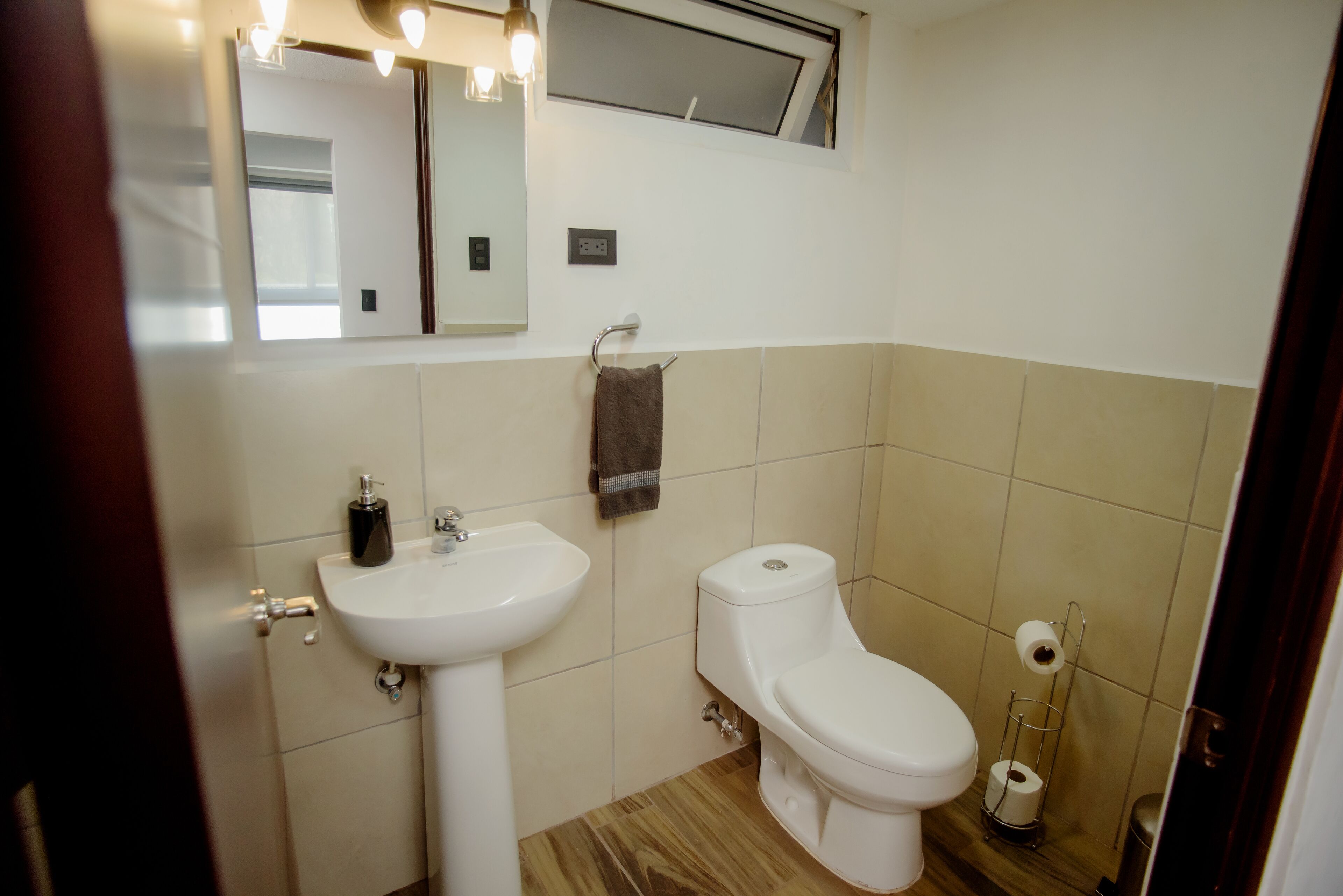 Un bagno con lavandino, wc e specchio.