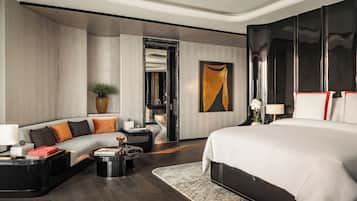 Una habitación de hotel moderna con una cama grande, un sofá, una mesita de café y un escritorio.