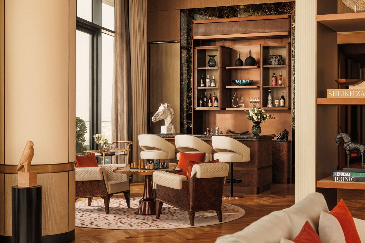 A well-lit, spacious living area with a large window, a fireplace, a bookshelf, and a coffee table.