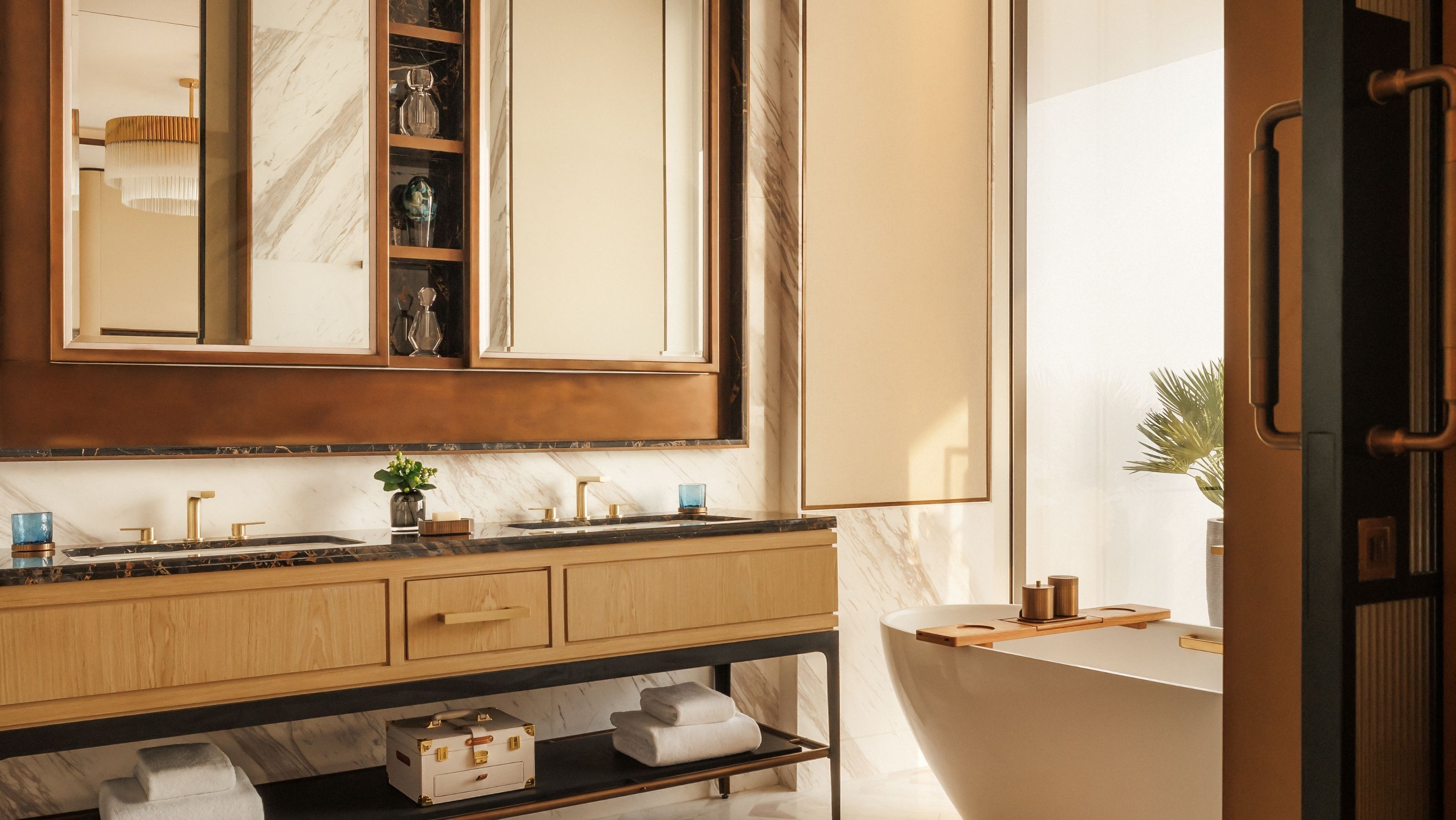 A modern bathroom with a marble countertop, wooden vanity, and a large mirror.