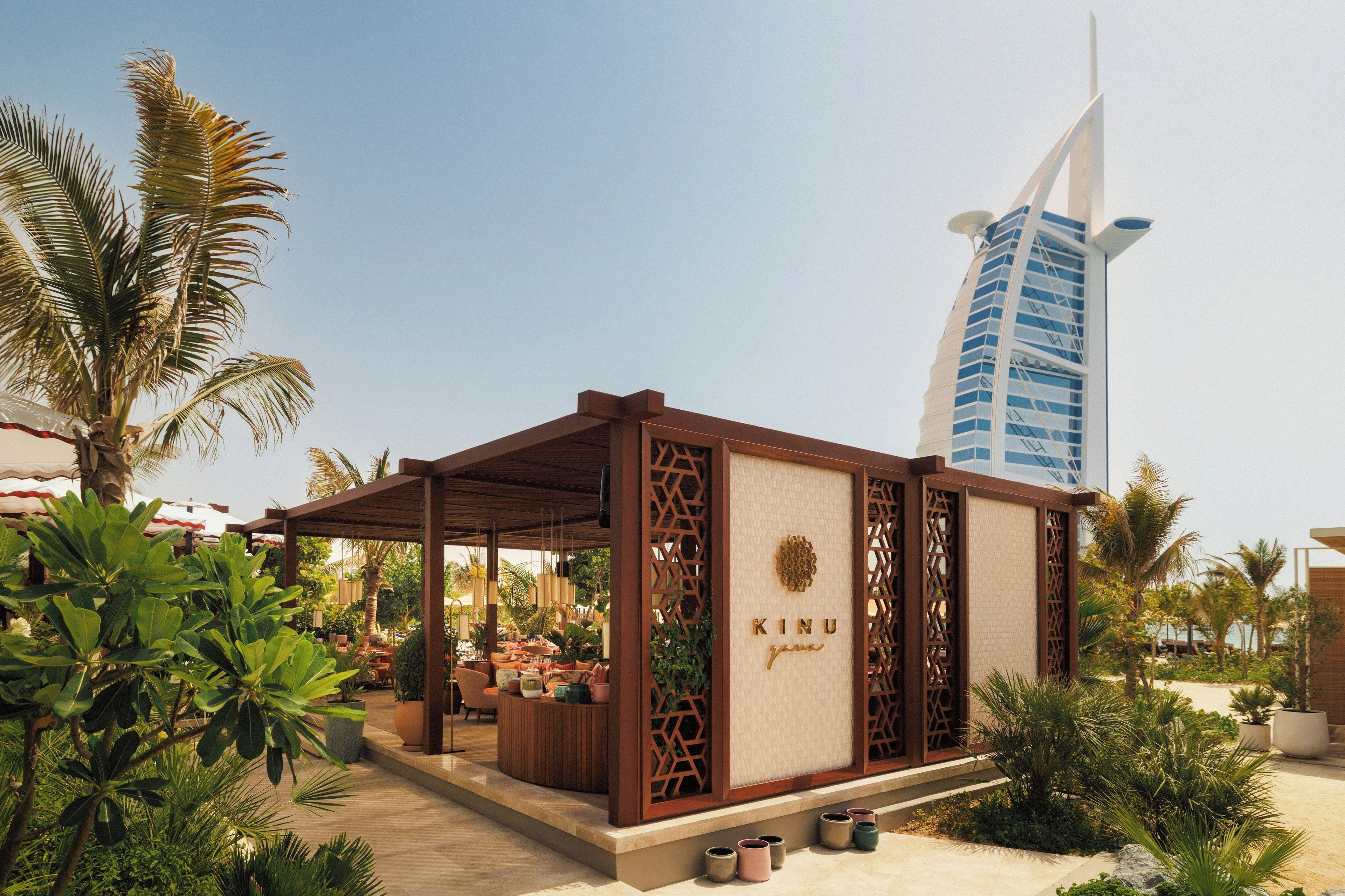 A covered outdoor seating area with a view of a distinctive building in the background.