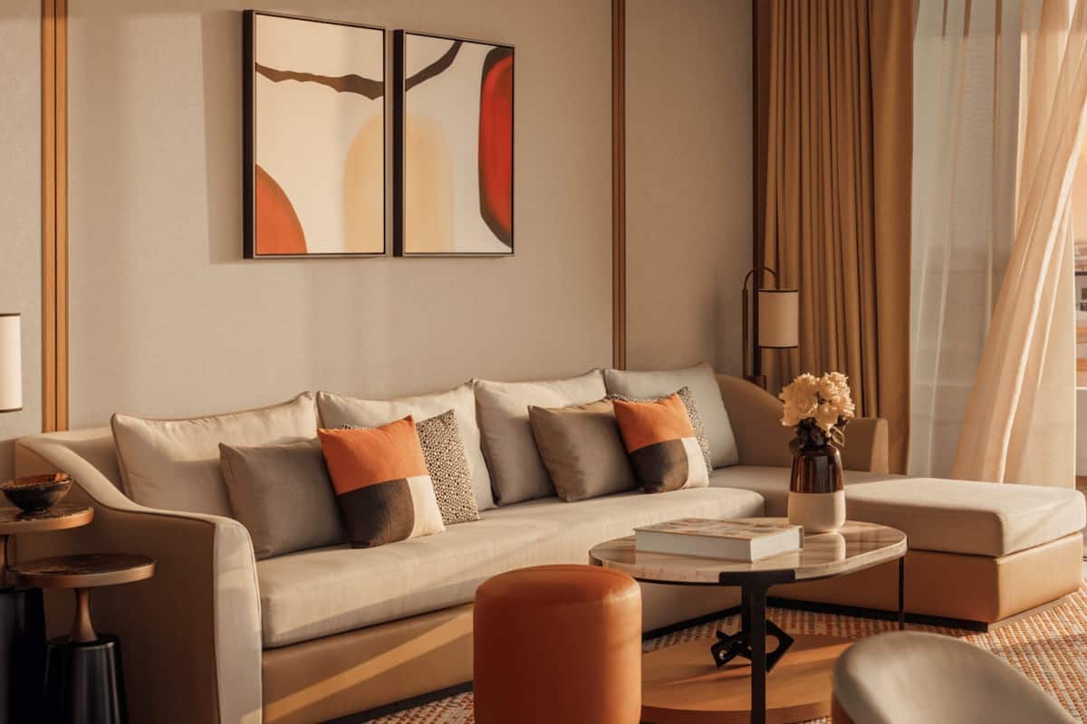 A modern living room with a sofa, coffee table, and a view of a cityscape.