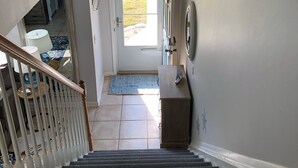 A staircase leading to a landing with a door to the outside. - Walk to beach. Perfect for families & couples. Pool & tennis onsite. (Fernandina Beach)