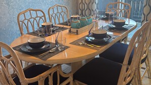 A dining area with a round table, chairs, and a decorative wall piece. - Walk to beach. Perfect for families & couples. Pool & tennis onsite. (Fernandina Beach)