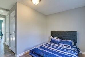 Ein Schlafzimmer mit einem Bett, einem Kopfteil und einer Tür.