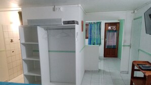 Una habitación con cama, armario, escritorio y silla.