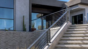 A modern staircase leading to a building with large windows and a minimalist design. - Gatsby by Fieldtrip - 5 Bd Modern Luxury with Infinity Pool & Game Room (Yucca Valley)