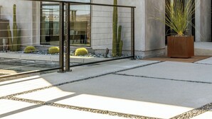 A modern building with large windows, a concrete facade, and a cactus garden in front. - Gatsby by Fieldtrip - 5 Bd Modern Luxury with Infinity Pool & Game Room (Yucca Valley)