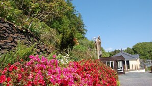 Eine Steinsäule, eine Statue und ein Gebäude mit einem geneigten Dach.