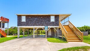 A two-story wooden building with a balcony and a staircase leading to a deck.