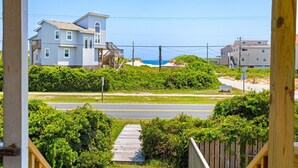 A coastal residential area with houses, a wooden deck, and a road.