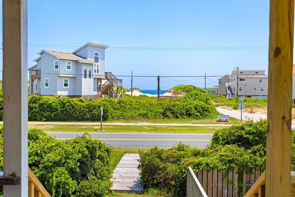 A coastal residential area with houses, a wooden deck, and a road. - Sandcastle - 500ft to Beach w/ pool (Nags Head)