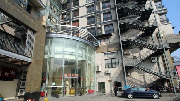 A multi-story building with a glass entrance, outdoor seating, and a fire escape.