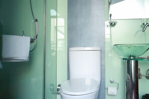 A modern bathroom with a glass shower enclosure, a white toilet, and a glass sink with a chrome faucet. - Yasi Apartment Hotel (Shanghai)