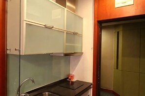A compact kitchen with a sink, a small countertop, and a cabinet above the sink. - Yasi Apartment Hotel (Shanghai)
