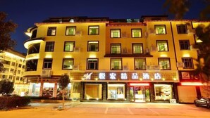 Un hotel de varios pisos con letreros iluminados y múltiples balcones.