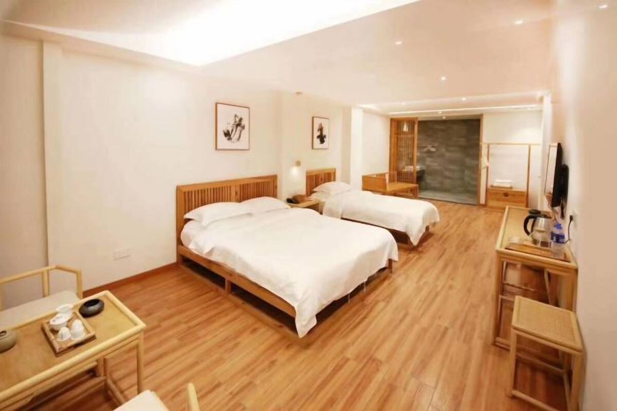 Une chambre d’hôtel avec deux lits, un bureau, une chaise et une petite table avec un plateau.