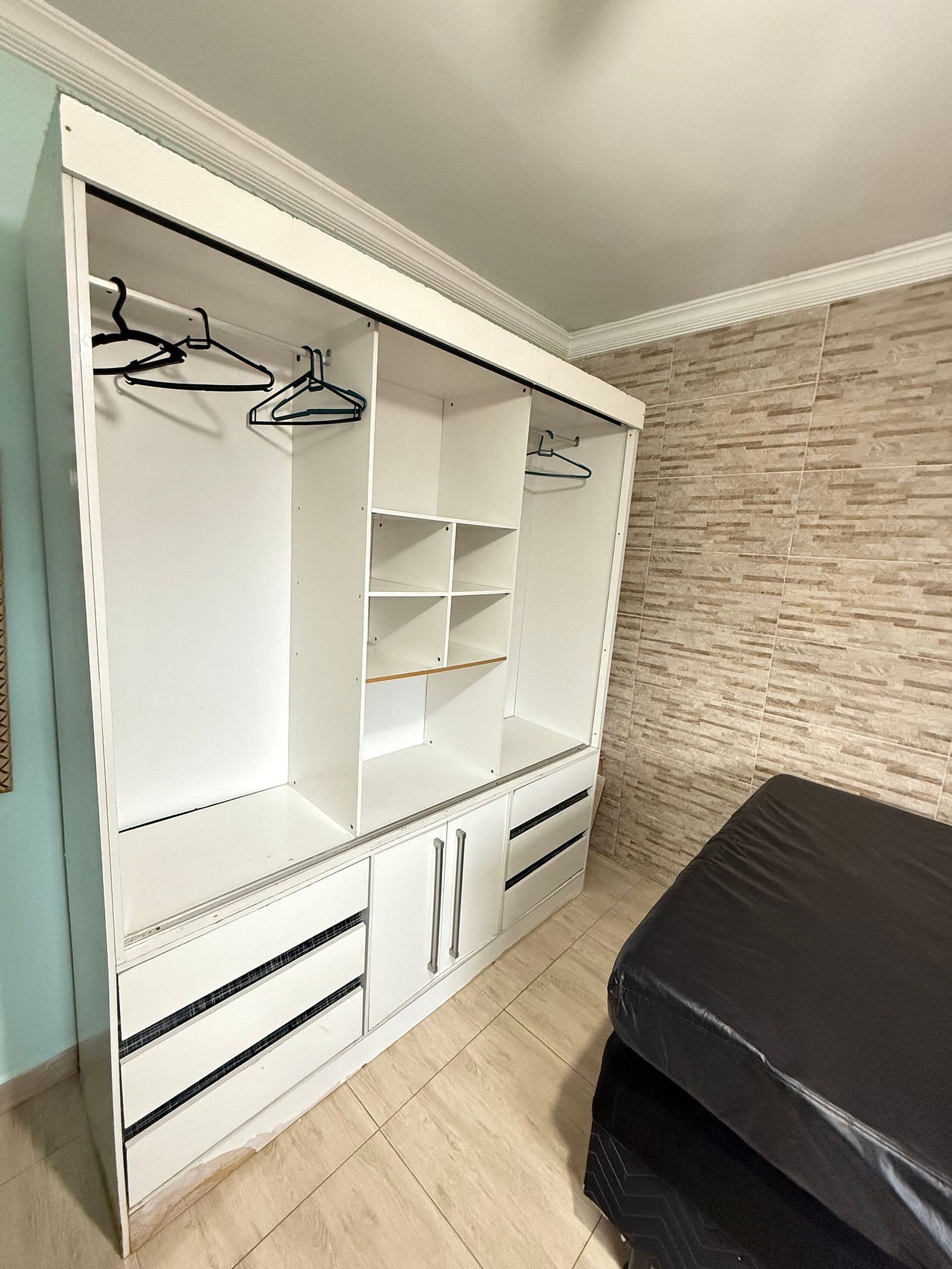 Ein begehbarer Kleiderschrank mit offenen Regalen, Ablageflächen und Schubladen.
