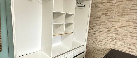 Ein begehbarer Kleiderschrank mit offenen Regalen, Ablageflächen und Schubladen.