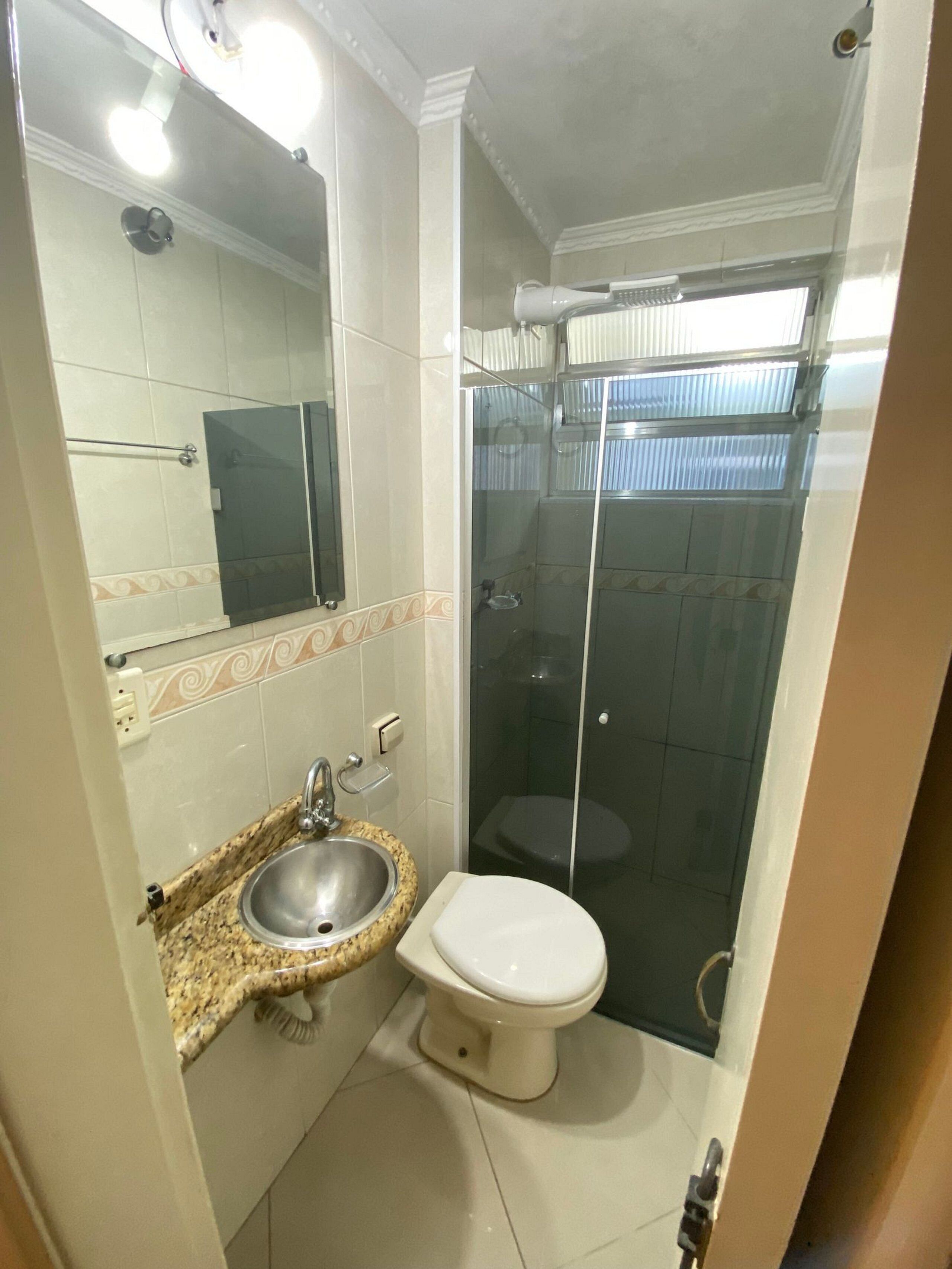 A bathroom with a sink, toilet, and glass-enclosed shower.