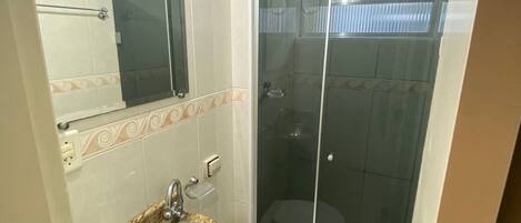 A bathroom with a sink, toilet, and glass-enclosed shower.