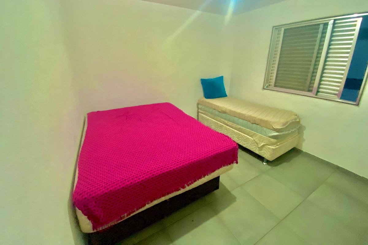 A small, well-lit room with a bed and a sofa.