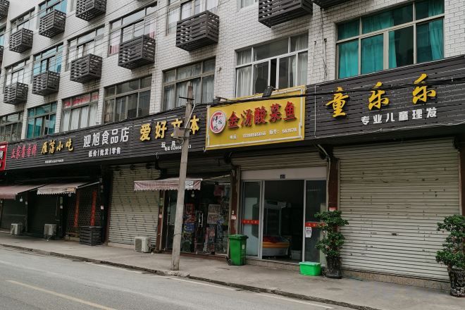 A street view of a row of closed shops with visible signage.