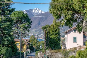 A residential street with houses, a mountain in the background, and a clear sky. - Primula Apartment by Wonderful Italy (Bellagio)