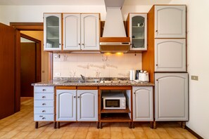 A kitchen with white cabinets, a microwave, and a sink. - Primula Apartment by Wonderful Italy (Bellagio)