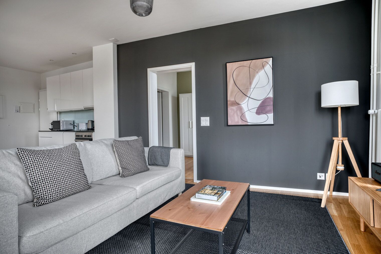 A modern living room with a grey sofa, a wooden coffee table, and a floor lamp.