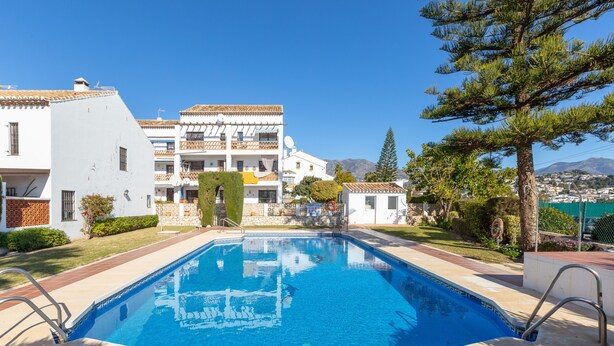 A swimming pool with a clear blue water, surrounded by a paved deck. - VALLEVERDE - Cosy apartment with shared pool and free WiFi. (Mijas)