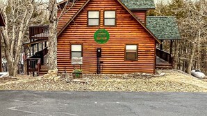 A log cabin with a green wreath on the door, surrounded by trees. - Newly remodeled Lake Frontage Cabin Hot Tub Arcade 2 Fire pit areas TRIPLE Decks (Golden)