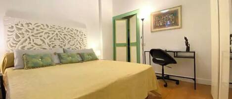 A bedroom with a bed, a desk, and a chair.