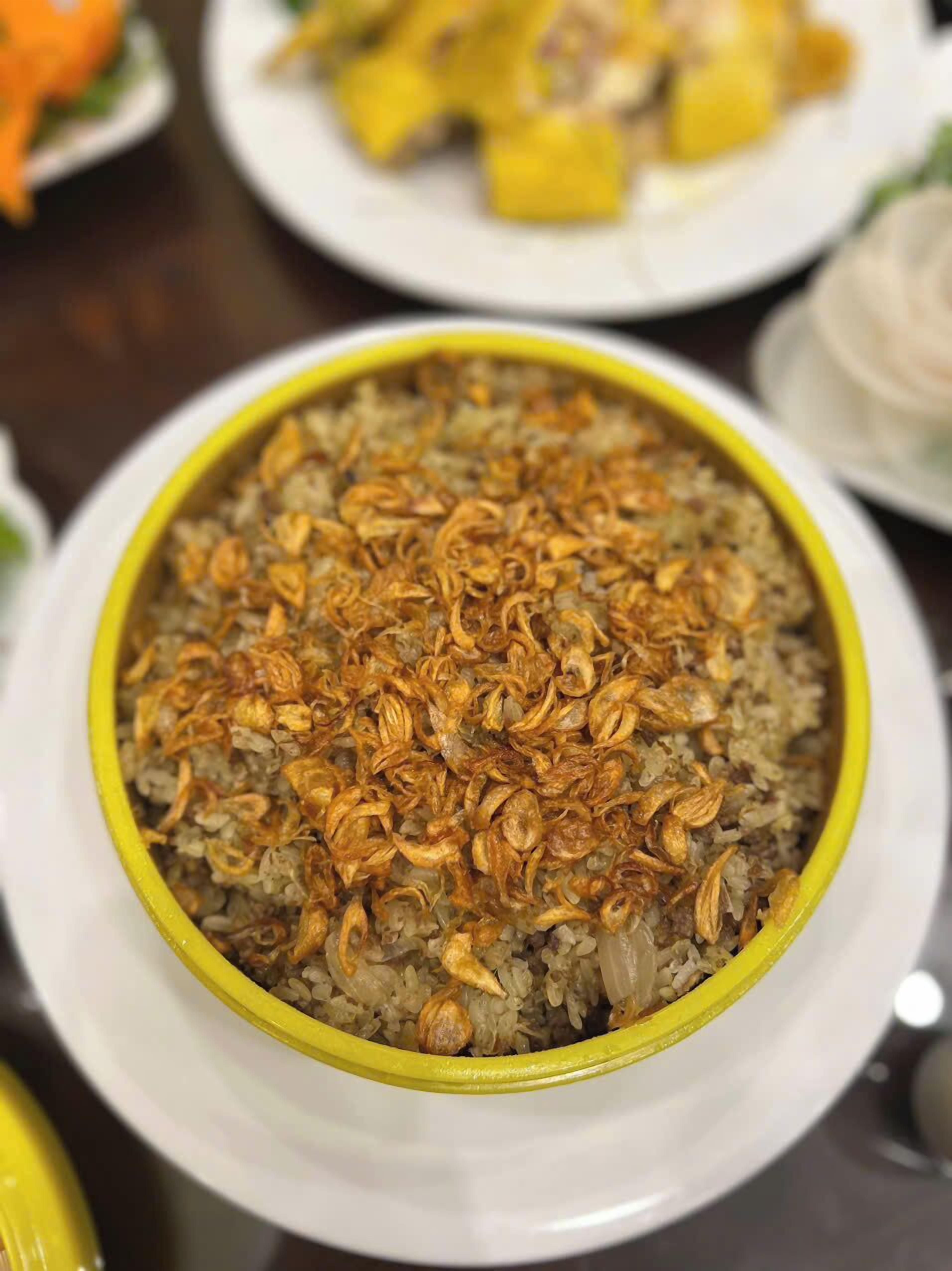 A bowl of rice topped with fried onions.