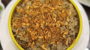 A bowl of rice topped with fried onions.