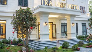 Un edificio blanco con un letrero que dice 'TRA LINH HOTEL'.