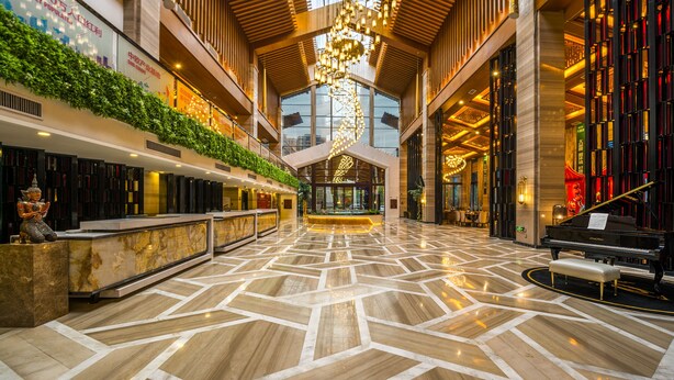 A spacious lobby with a geometric marble floor, a grand chandelier, and a piano. - biguiyuan (Jiangmen)
