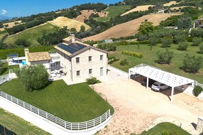 A two-story house with a solar panel roof, a covered carport, and a fenced yard. - Villa Ada by MMega Villas  (Lapedona)