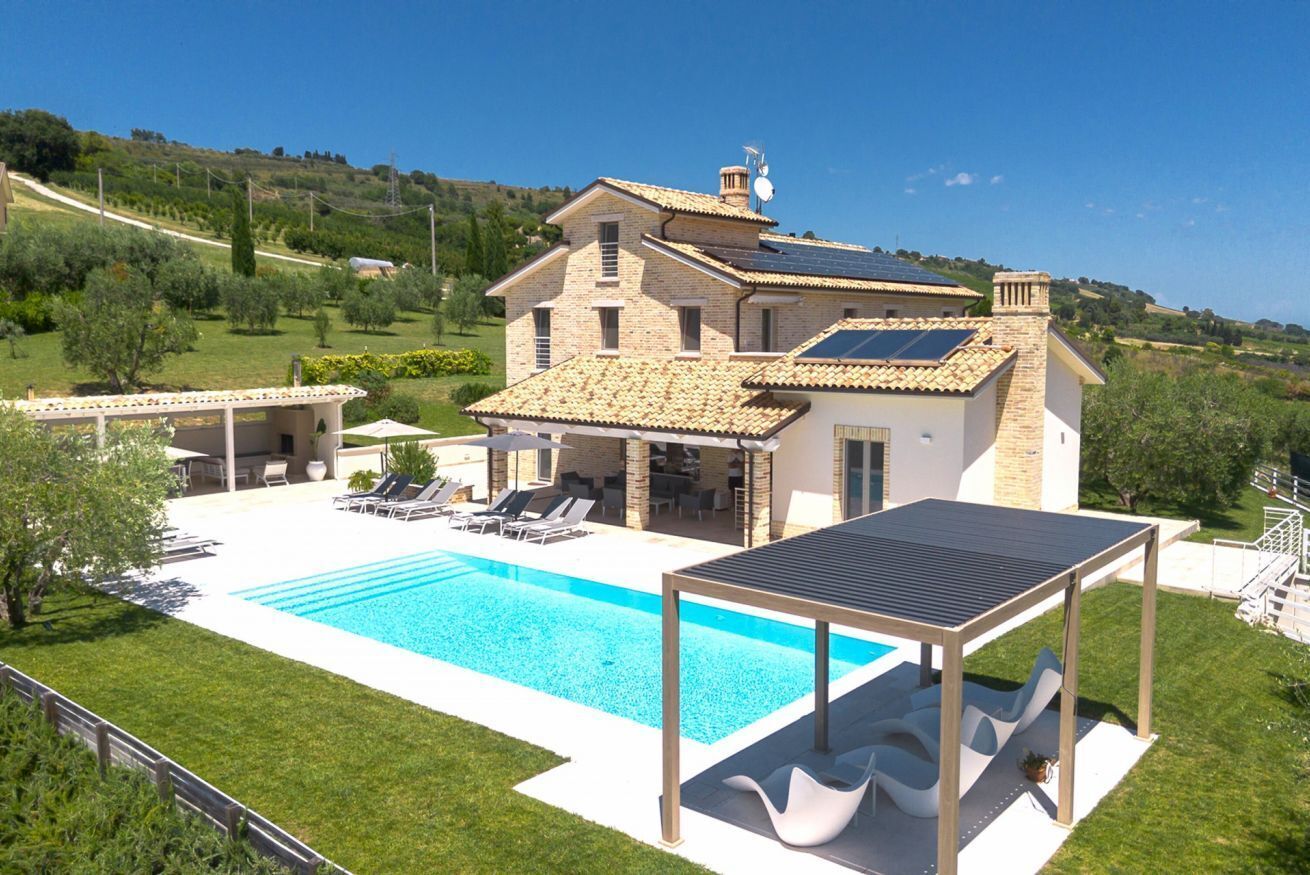 Une villa dotée d’une piscine, d’un espace extérieur aménagé et d’un panneau solaire.