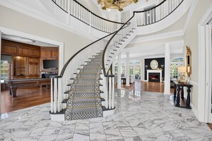 Un magnifique escalier, dont les marches sont recouvertes de marbre, mène à un palier situé au deuxième étage.