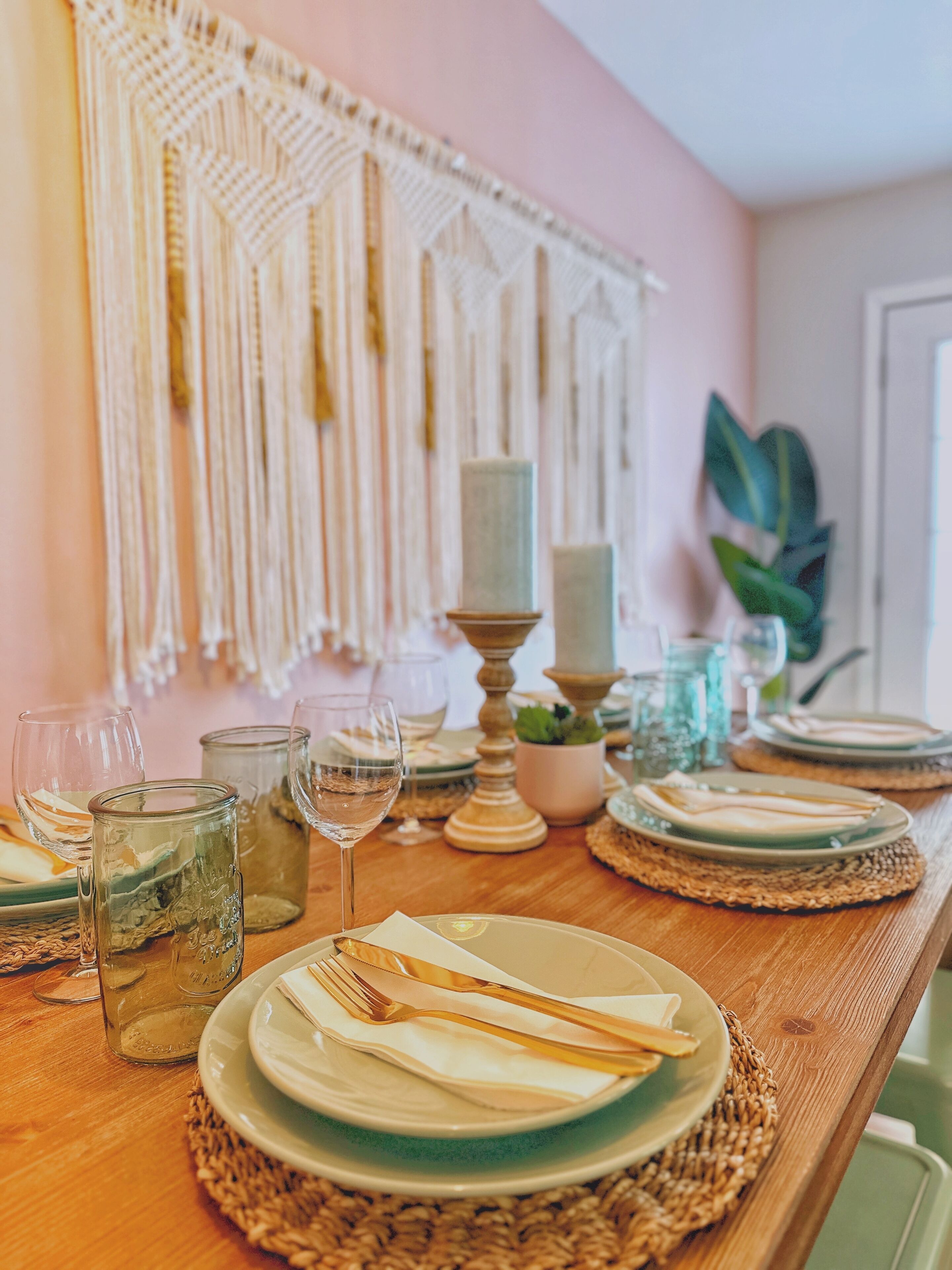 Une table à manger dressée avec des assiettes, des verres et une bougie.