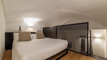 A modern bedroom with a bed, headboard, and wall-mounted lights.