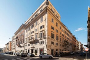 En byggnad med flera våningar i en klassisk arkitektonisk stil, med en restaurang på bottenvåningen och flera butiker på markplan.