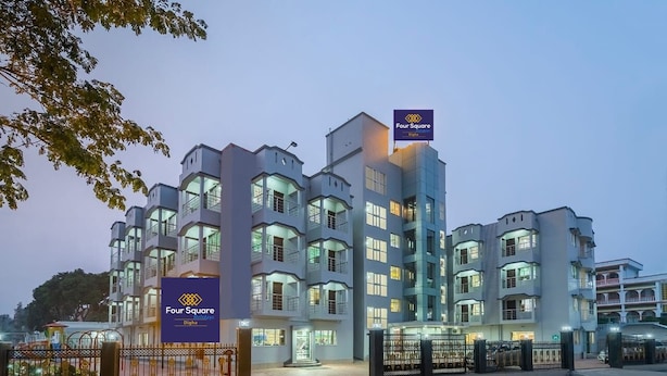 A multi-story hotel with a modern design, featuring balconies and large windows. - Four Square Holidayz (Kanthi)