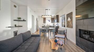 A modern living room with a grey sofa, a wooden coffee table, and a fireplace.