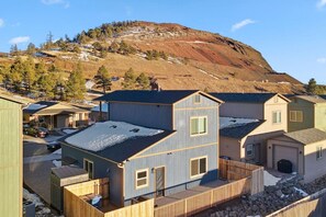 A residential area with houses, a wooden deck, and a mountain in the background.