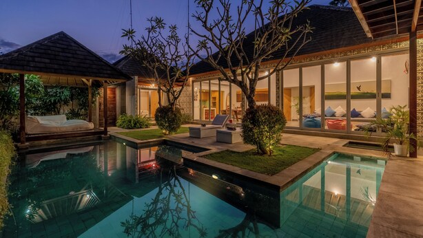 A modern pool area with a clear pool, lounge chairs, and a covered seating area. - Villa Becca Seminyak (Seminyak)